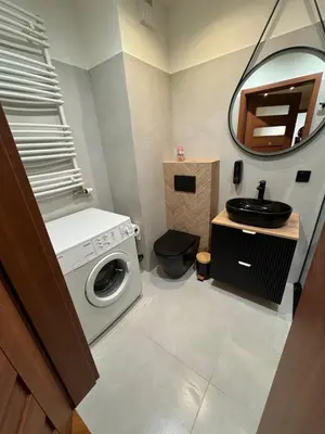 a bathroom with a washing machine and a sink at Apartament Bajeczny 87 - 5 min to Tauron Arena Cracow - beside the Vistula River in Kraków