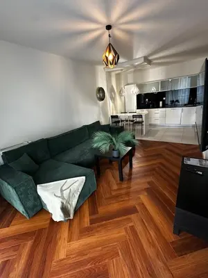 a living room with a green couch and a table at Apartament Bajeczny 87 - 5 min to Tauron Arena Cracow - beside the Vistula River in Kraków