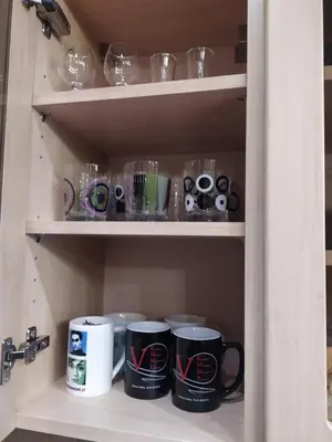 a cupboard with coffee mugs and other items on it at Origami Apartament in Kraków