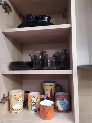 a cupboard filled with lots of pots and pans at Origami Apartament in Kraków