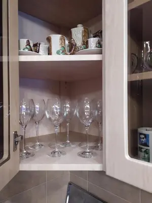 a row of wine glasses in a cabinet at Origami Apartament in Kraków