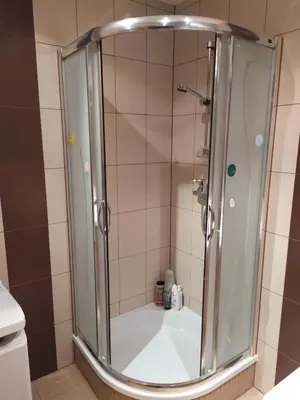 a shower with a glass door in a bathroom at Origami Apartament in Kraków