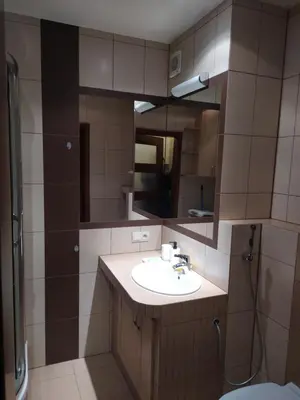 a bathroom with a sink and a mirror at Origami Apartament in Kraków