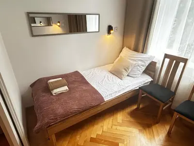 a small bed in a room with a mirror at Old Cracow Apartment I in Kraków