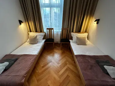 two beds in a room with a window at Old Cracow Apartment I in Kraków
