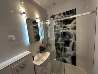 a white bathroom with a shower and a sink at Old Cracow Apartment I in Kraków