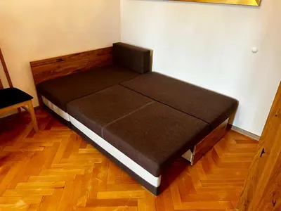 a small bed in a room with a wooden floor at Old Cracow Apartment I in Kraków