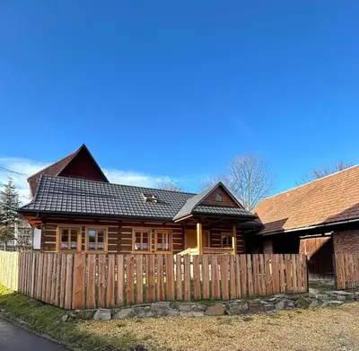 a log home with a fence in front of it at Domek Sidzina in Sidzina