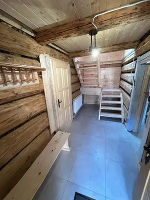 an empty room with a ladder in a wooden cabin at Domek Sidzina in Sidzina