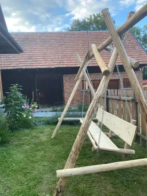 a wooden swing in the yard of a house at Domek Sidzina in Sidzina