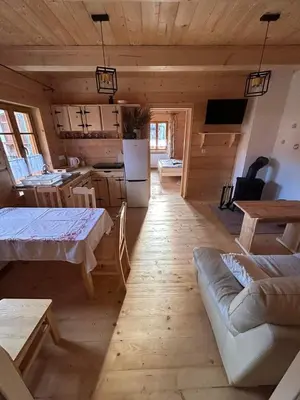 a kitchen and living room in a log cabin at Domek Sidzina in Sidzina