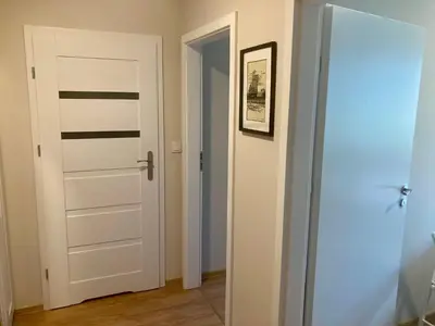a hallway with a door and a picture on the wall at Apartament Łagiewniki 2 in Kraków