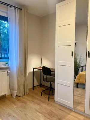 a door in a room with a desk and a chair at Apartament Łagiewniki 2 in Kraków