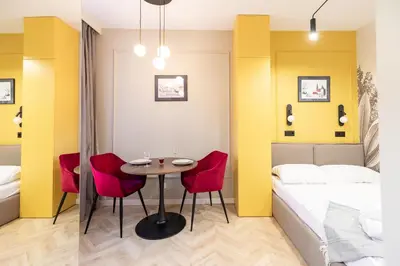 a room with a bed and a table and chairs at Apartamenty Limanowskiego in Kraków
