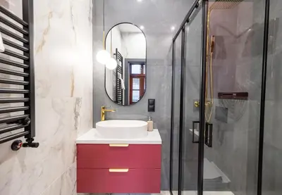 a bathroom with a sink and a mirror at Apartamenty Limanowskiego in Kraków