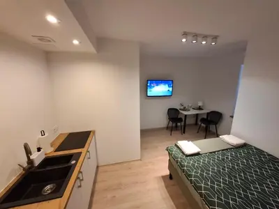 a bedroom with a bed and a kitchen and a table at ApartamentyM&K in Balice
