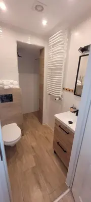 a bathroom with a toilet and a sink and a mirror at ApartamentyM&K in Balice
