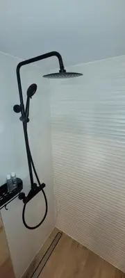 a black lamp sitting next to a white wall at ApartamentyM&K in Balice