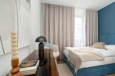 a bedroom with a bed and a table with a chair at Klimatyzowany Apartament Blisko Parku w Krakowie z 3 Sypialniami, Wanną i Parkingiem by Renters Prestige in Kraków