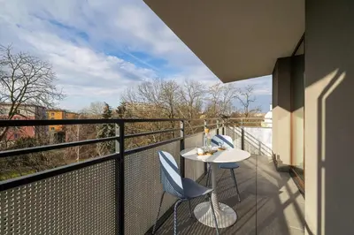 a balcony with two chairs and a table on a balcony at Klimatyzowany Apartament Blisko Parku w Krakowie z 3 Sypialniami, Wanną i Parkingiem by Renters Prestige in Kraków