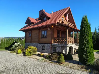 a large wooden house with a red roof at Domek Wypoczynkowy Relax in Bystra