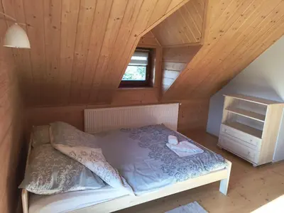 a bed in a room with a wooden ceiling at Domek Wypoczynkowy Relax in Bystra