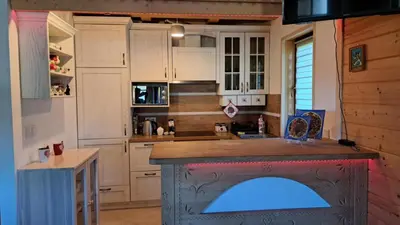 a kitchen with white cabinets and a blue island at Domek Wypoczynkowy Relax in Bystra
