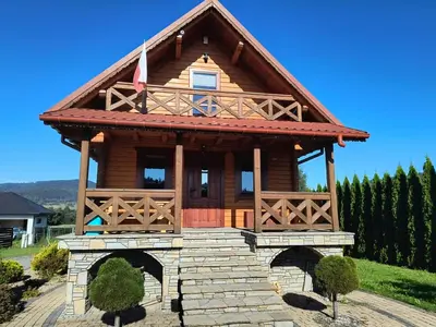 a log cabin with a flag on top at Domek Wypoczynkowy Relax in Bystra