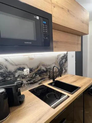 a kitchen counter with a sink and a microwave at Kazimierz Art Apartment for 2 in Kraków