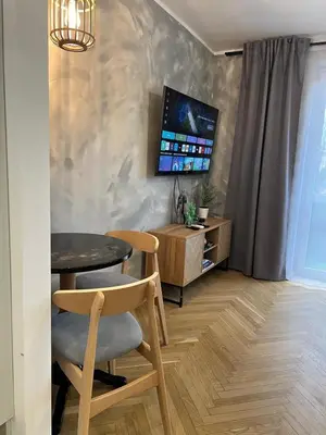 a dining room with a table and a tv at Kazimierz Art Apartment for 2 in Kraków