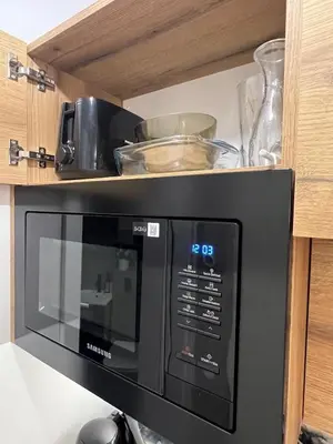 a microwave oven with some dishes on top of it at Kazimierz Art Apartment for 2 in Kraków