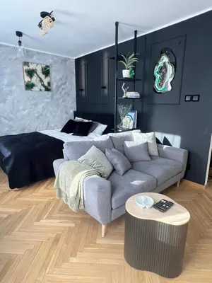 a living room with a couch and a bed at Kazimierz Art Apartment for 2 in Kraków