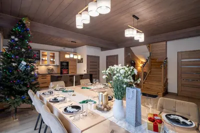 a dining room with a table and a christmas tree at Domek nad Potokiem 2 in Nowy Targ