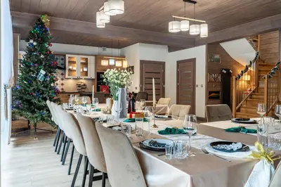 a dining room with a table and a christmas tree at Domek nad Potokiem 2 in Nowy Targ