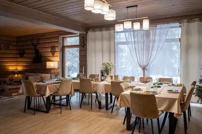 a dining room with tables and chairs and a large window at Domek nad Potokiem 2 in Nowy Targ