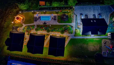 a swimming pool with blue water in a yard at Zdrojowy Gościniec - Apartament Premium na wyłącznosć in Rabka