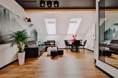 a dining room with a table with chairs and a couch at Zdrojowy Gościniec - Apartament Premium na wyłącznosć in Rabka