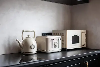 a kitchen counter with a microwave and a tea kettle at Luksusowy Apartament na Podgórzu - by Upstairs in Kraków