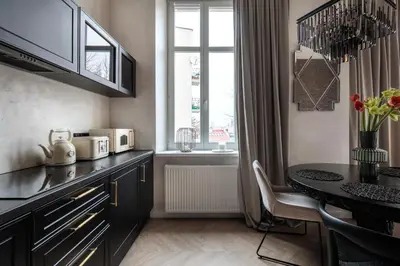 a kitchen with a table and a dining room at Luksusowy Apartament na Podgórzu - by Upstairs in Kraków