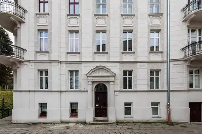 a large white building with a door at Luksusowy Apartament na Podgórzu - by Upstairs in Kraków