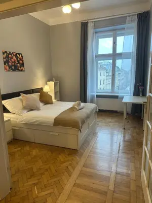 a bedroom with a bed and a large window at Queen's apartment from the 14th century - 130 m2 AC in Kraków