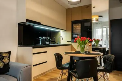 a kitchen with a table and chairs in a room at Apartament Glamour Garden Kraków in Kraków