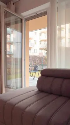 a bedroom with a large sliding glass door to a patio at Apartament Glamour Garden Kraków in Kraków
