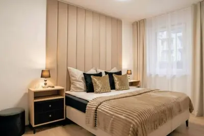 a bedroom with a bed with pillows and a window at Apartament Glamour Garden Kraków in Kraków