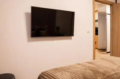 a flat screen tv on the wall of a bedroom at Apartament Glamour Garden Kraków in Kraków