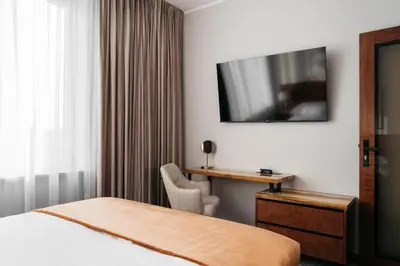 a hotel room with a bed and a desk and a television at Native Apartments Lenartowicza 17 in Kraków