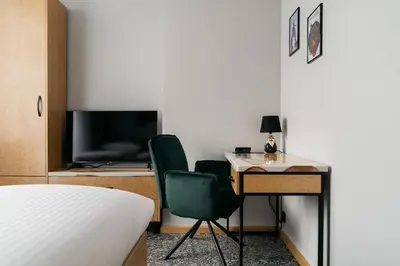 a bedroom with a bed and a desk and a television at Native Apartments Lenartowicza 17 in Kraków