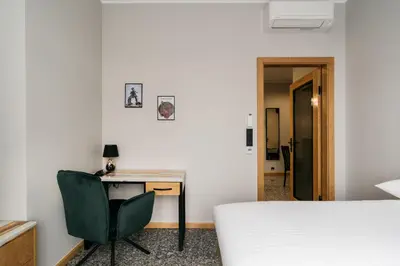 a bedroom with a desk and a bed and a chair at Native Apartments Lenartowicza 17 in Kraków
