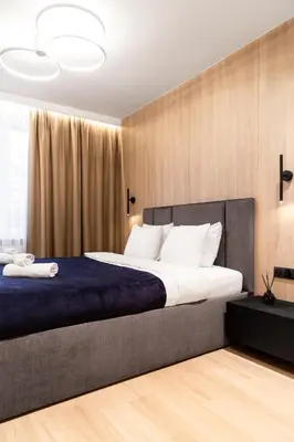 a bedroom with a large bed with a blue blanket at Househost Apartment Retoryka in Kraków