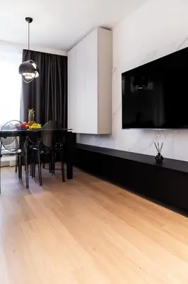 a dining room with a table and a tv on a wall at Househost Apartment Retoryka in Kraków